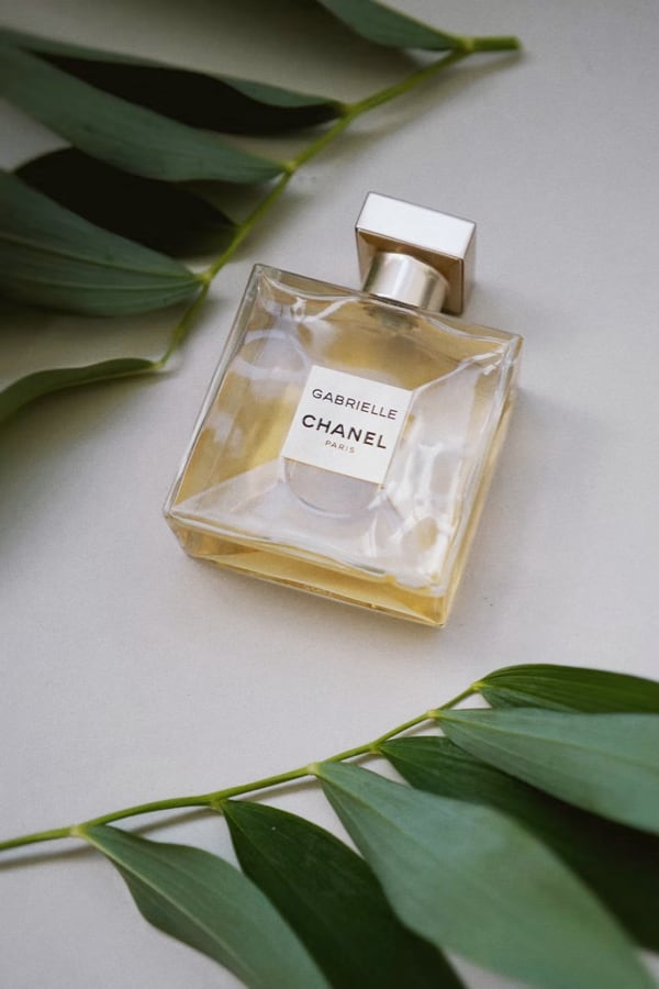 Gabrielle Chanel perfume surrounded by leaves desktop