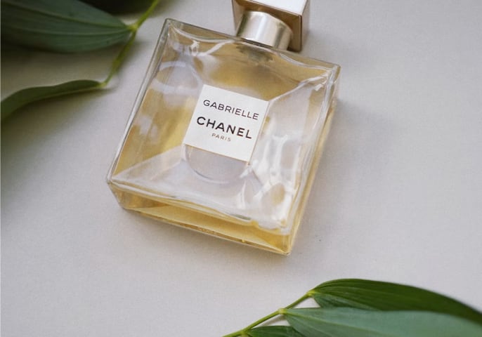 Gabrielle Chanel perfume surrounded by leaves